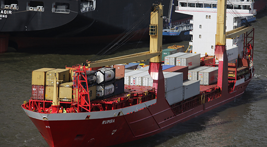 A ship, loaded with containers, leaving its port.